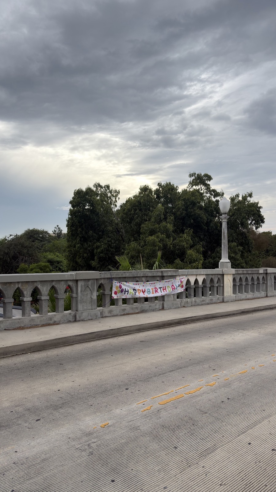 A hand-painted birthday banner tied to the railing of the Shakespeare Bridge